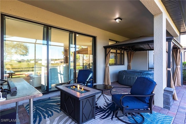 view of patio / terrace with a hot tub and an outdoor fire pit