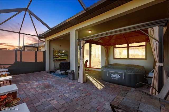 patio terrace at dusk featuring a lanai