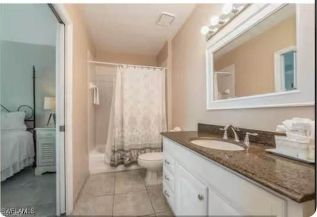 full bathroom featuring shower / bath combo with shower curtain, tile patterned floors, vanity, and toilet