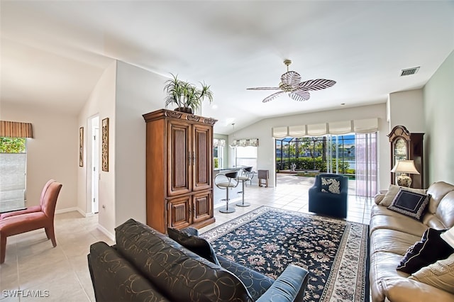 tiled living room with vaulted ceiling, ceiling fan, and plenty of natural light