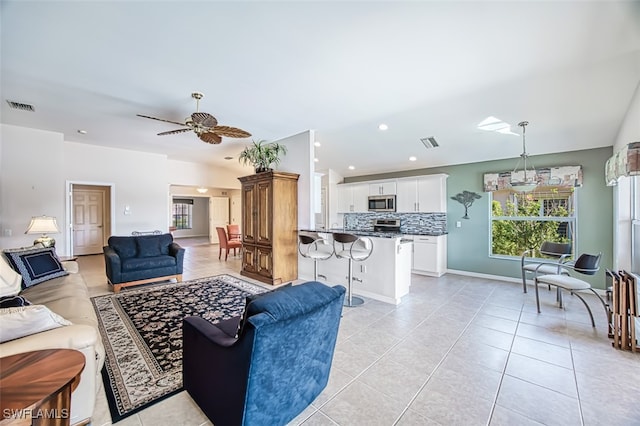 living room with ceiling fan and light tile patterned floors