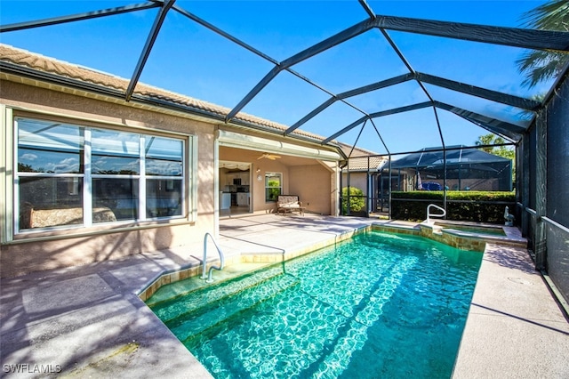 view of swimming pool featuring glass enclosure, a patio area, an in ground hot tub, and ceiling fan