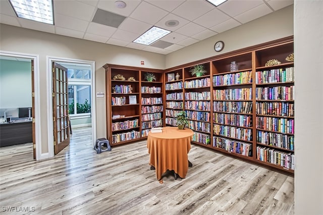 office space with a paneled ceiling and light hardwood / wood-style flooring