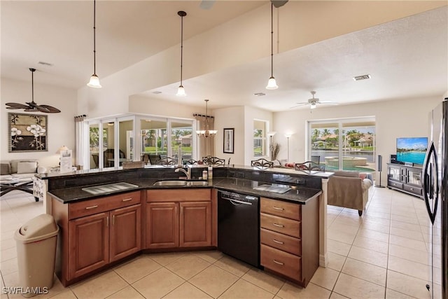 kitchen with black dishwasher, hanging light fixtures, stainless steel refrigerator, ceiling fan with notable chandelier, and sink