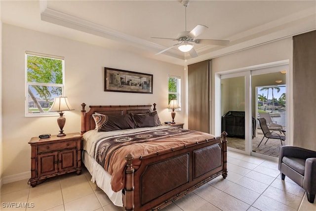 bedroom with multiple windows, access to exterior, a raised ceiling, light tile patterned flooring, and ceiling fan