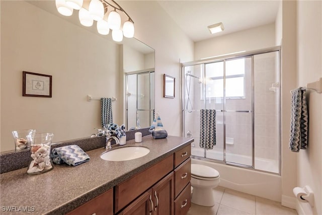 full bathroom with toilet, tile patterned floors, vanity, and shower / bath combination with glass door