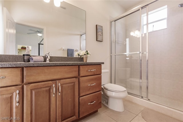 bathroom featuring ceiling fan, vanity, toilet, tile patterned floors, and an enclosed shower