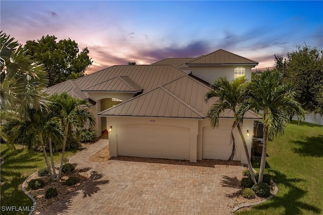 view of front of home with a garage and a lawn