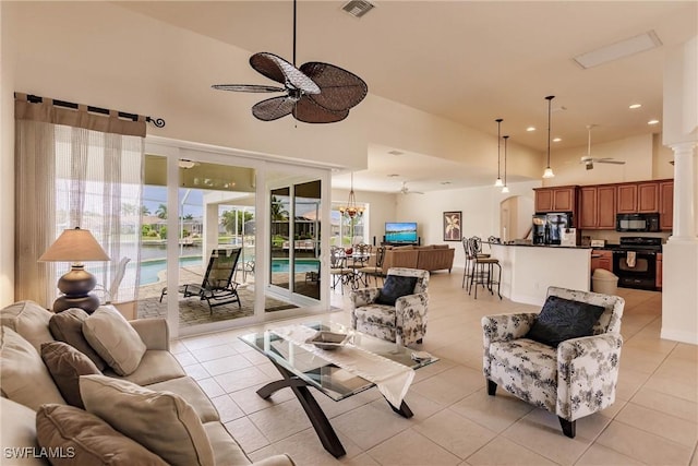 tiled living room featuring ceiling fan and a high ceiling