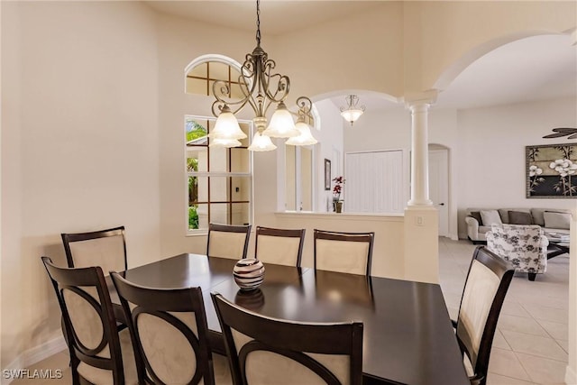 tiled dining room featuring ornate columns and a notable chandelier