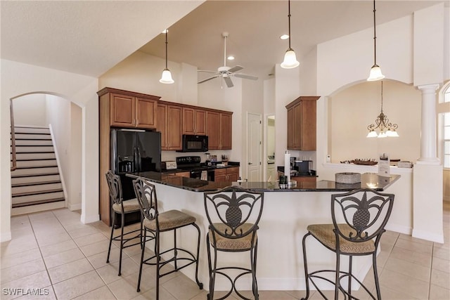 kitchen featuring black appliances, light tile patterned floors, high vaulted ceiling, and pendant lighting