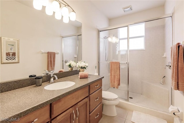 bathroom with toilet, tile patterned floors, vanity, and a shower with shower door