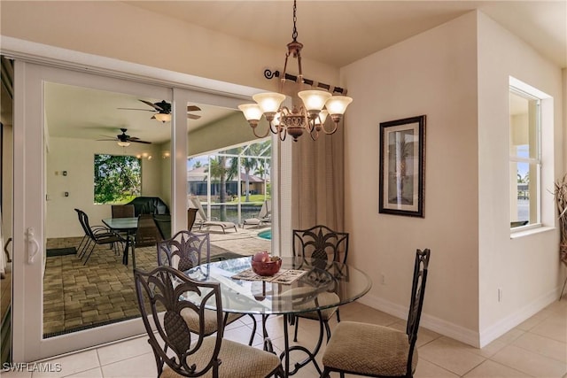 dining space featuring light tile patterned floors and ceiling fan with notable chandelier