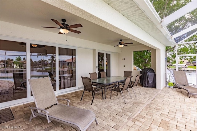 view of patio / terrace with a lanai, ceiling fan, and grilling area