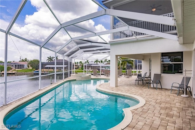 view of pool featuring a water view, glass enclosure, a patio, and an in ground hot tub