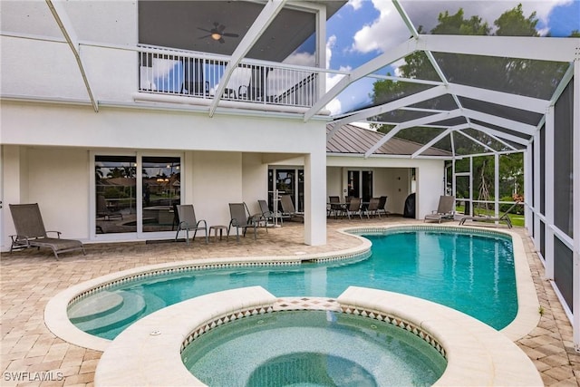 view of pool featuring ceiling fan, glass enclosure, an in ground hot tub, and a patio