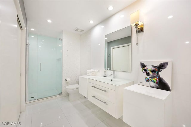 bathroom with tile patterned floors, toilet, vanity, and an enclosed shower