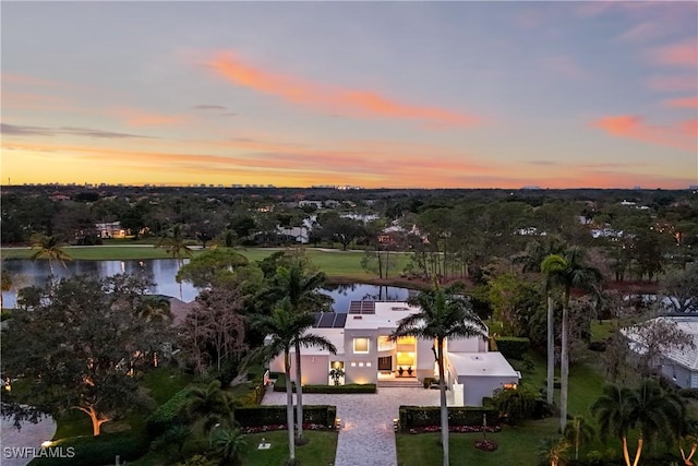 aerial view at dusk featuring a water view