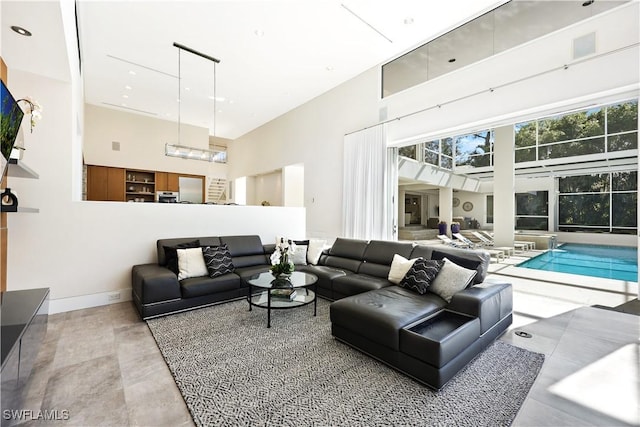 living room featuring a high ceiling and concrete flooring