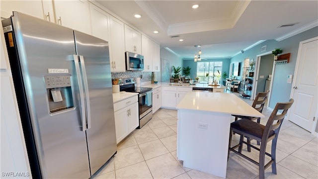 kitchen featuring appliances with stainless steel finishes, a center island, sink, kitchen peninsula, and a breakfast bar