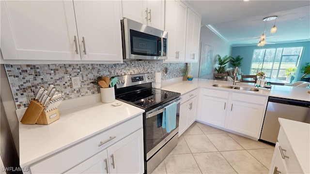 kitchen featuring ceiling fan, backsplash, white cabinetry, and appliances with stainless steel finishes