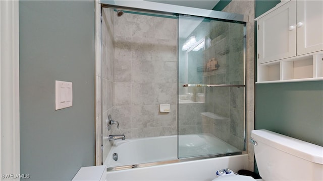 bathroom with toilet and bath / shower combo with glass door