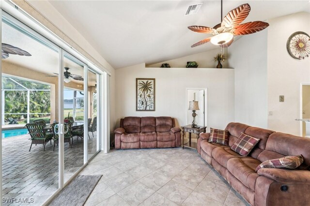 living room featuring lofted ceiling, light tile patterned floors, and ceiling fan