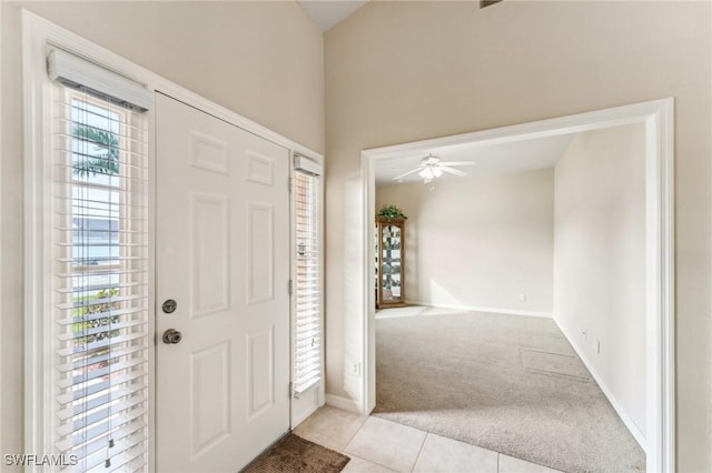 foyer entrance with a healthy amount of sunlight, light carpet, and ceiling fan