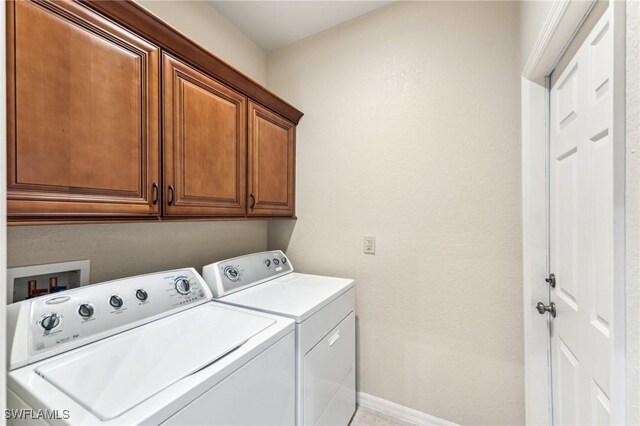 clothes washing area with cabinets and independent washer and dryer