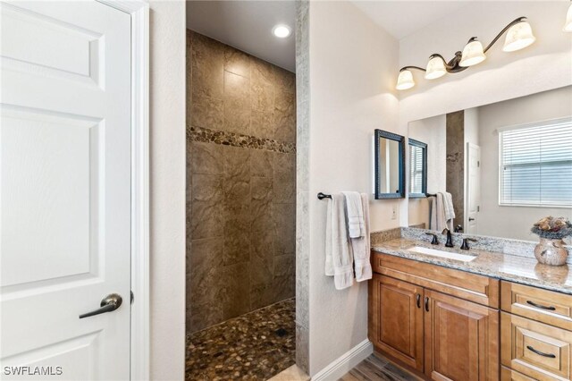 bathroom with vanity and a tile shower