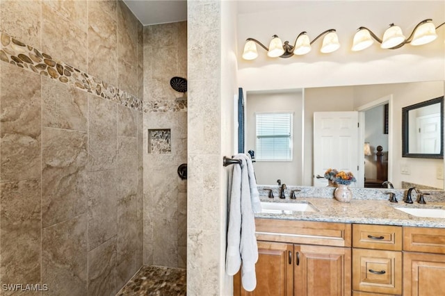 bathroom featuring tiled shower and vanity