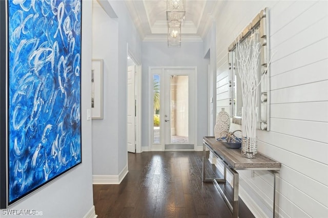 foyer featuring a tray ceiling, ornamental molding, and dark wood-type flooring