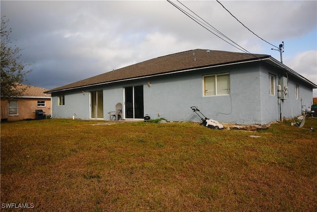 rear view of house featuring a lawn