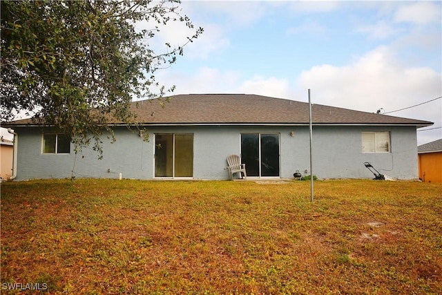 rear view of property featuring a lawn