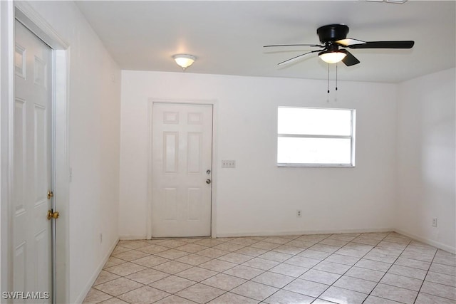 empty room with ceiling fan and light tile patterned floors