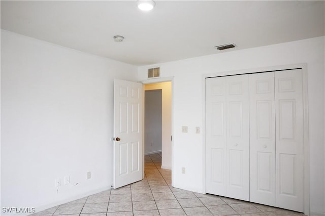 unfurnished bedroom featuring a closet and light tile patterned flooring