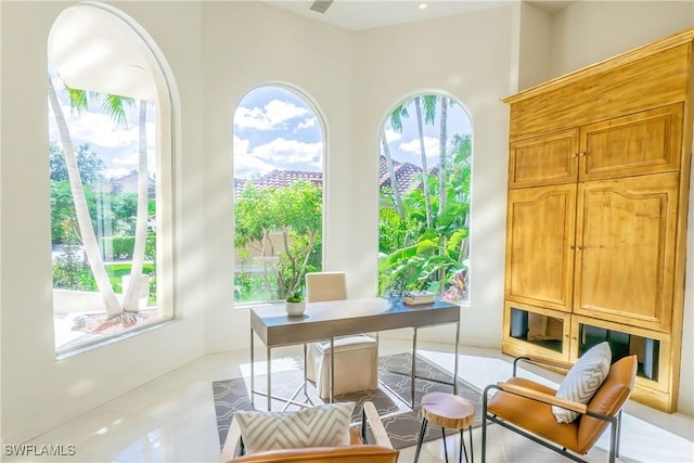 home office with light tile patterned floors and a wealth of natural light