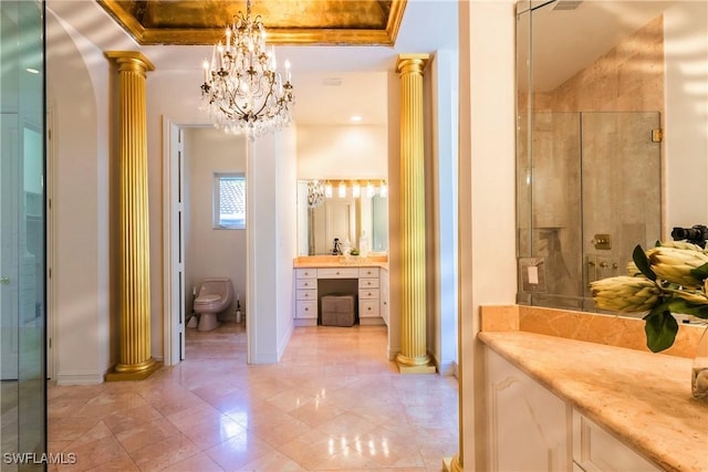 bathroom featuring decorative columns, toilet, vanity, and ornamental molding