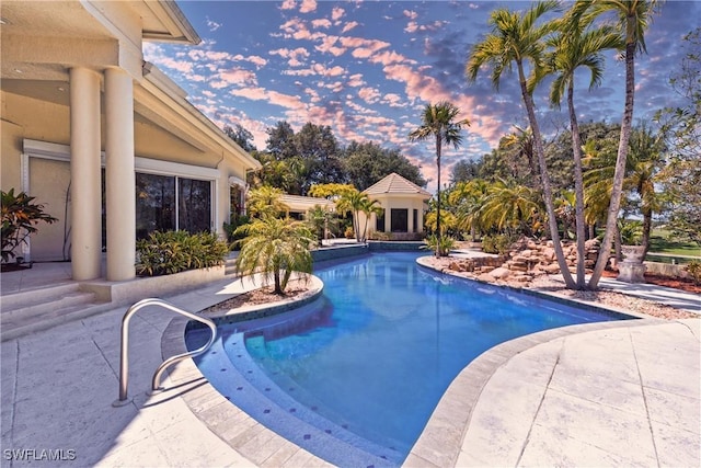 pool at dusk with a patio