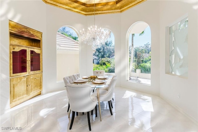 dining space with a high ceiling, ornamental molding, and an inviting chandelier