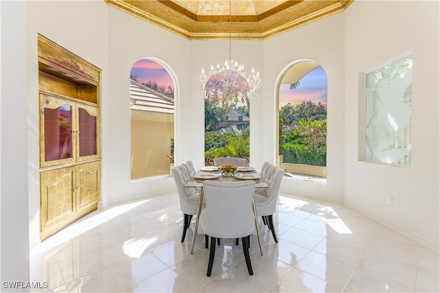 tiled dining room featuring a chandelier, crown molding, a towering ceiling, and a raised ceiling