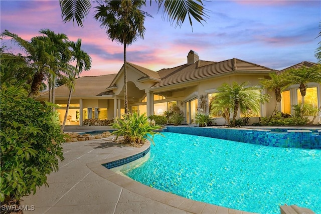 pool at dusk with a patio