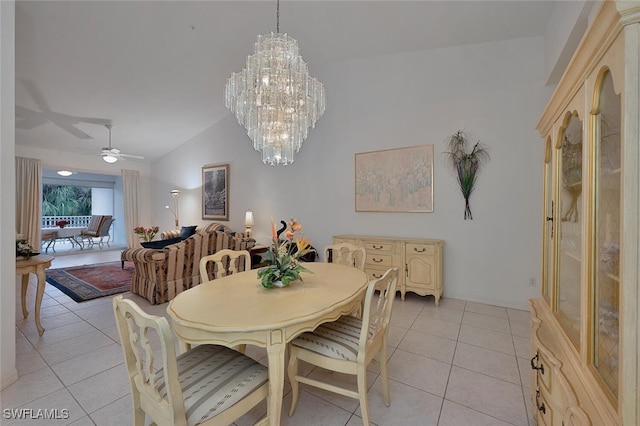 dining area with lofted ceiling, ceiling fan with notable chandelier, and light tile patterned flooring