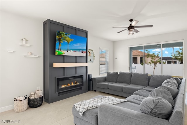 tiled living room featuring ceiling fan and a fireplace