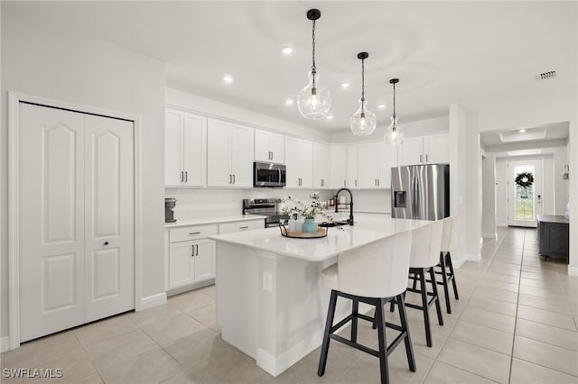 kitchen featuring white cabinetry, stainless steel appliances, sink, a kitchen island with sink, and light tile patterned floors