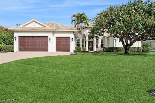 677 5th Ave N, Naples, FL 34102 - view of front of house with a front lawn, an attached garage, driveway, a tile roof, and stucco siding