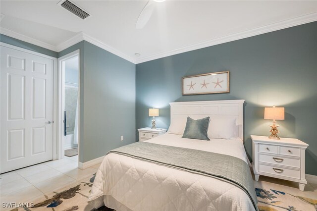 bedroom featuring light tile patterned floors, baseboards, visible vents, ensuite bath, and crown molding