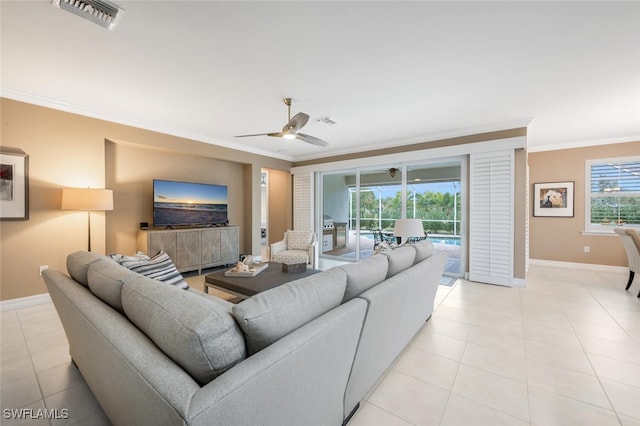 tiled living room featuring ceiling fan, crown molding, and plenty of natural light