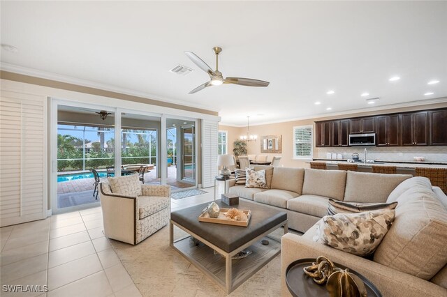 living room with ornamental molding, a ceiling fan, plenty of natural light, and light tile patterned floors