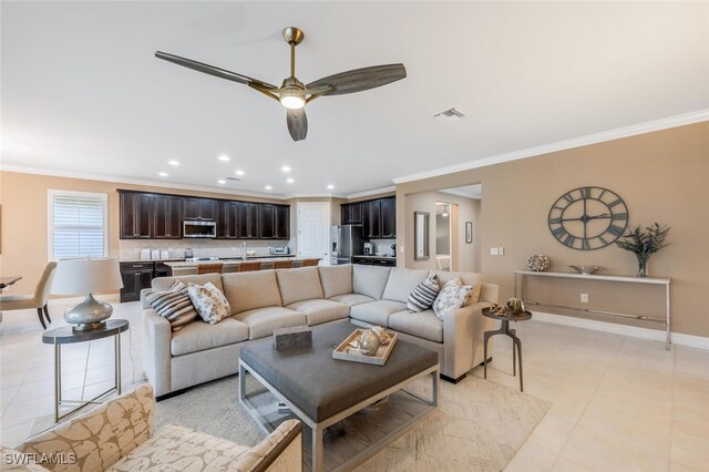 living room with sink, ceiling fan, and ornamental molding